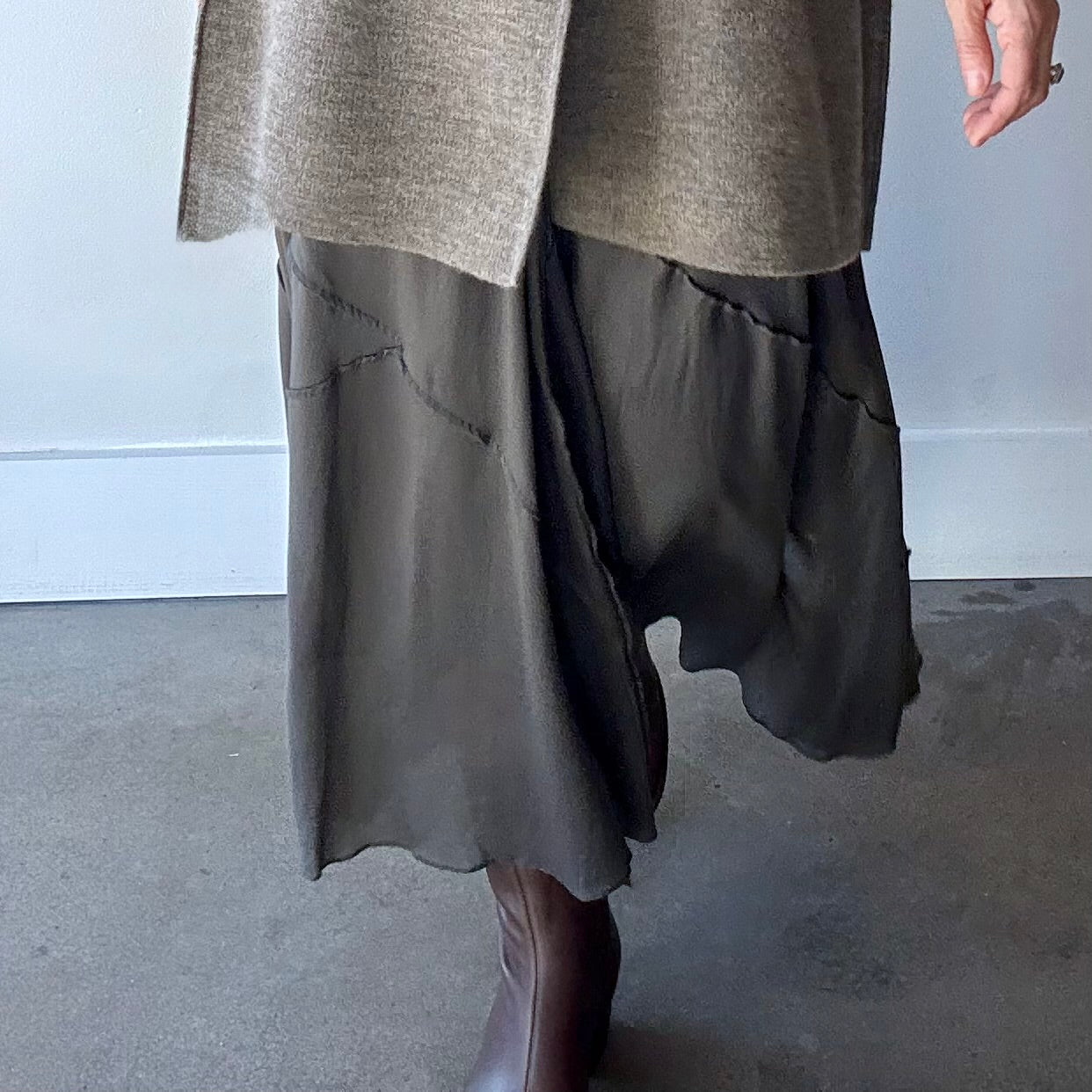 Close-up of model wearing dark grey Lauren Manoogian skirt, which is semi-transparent.