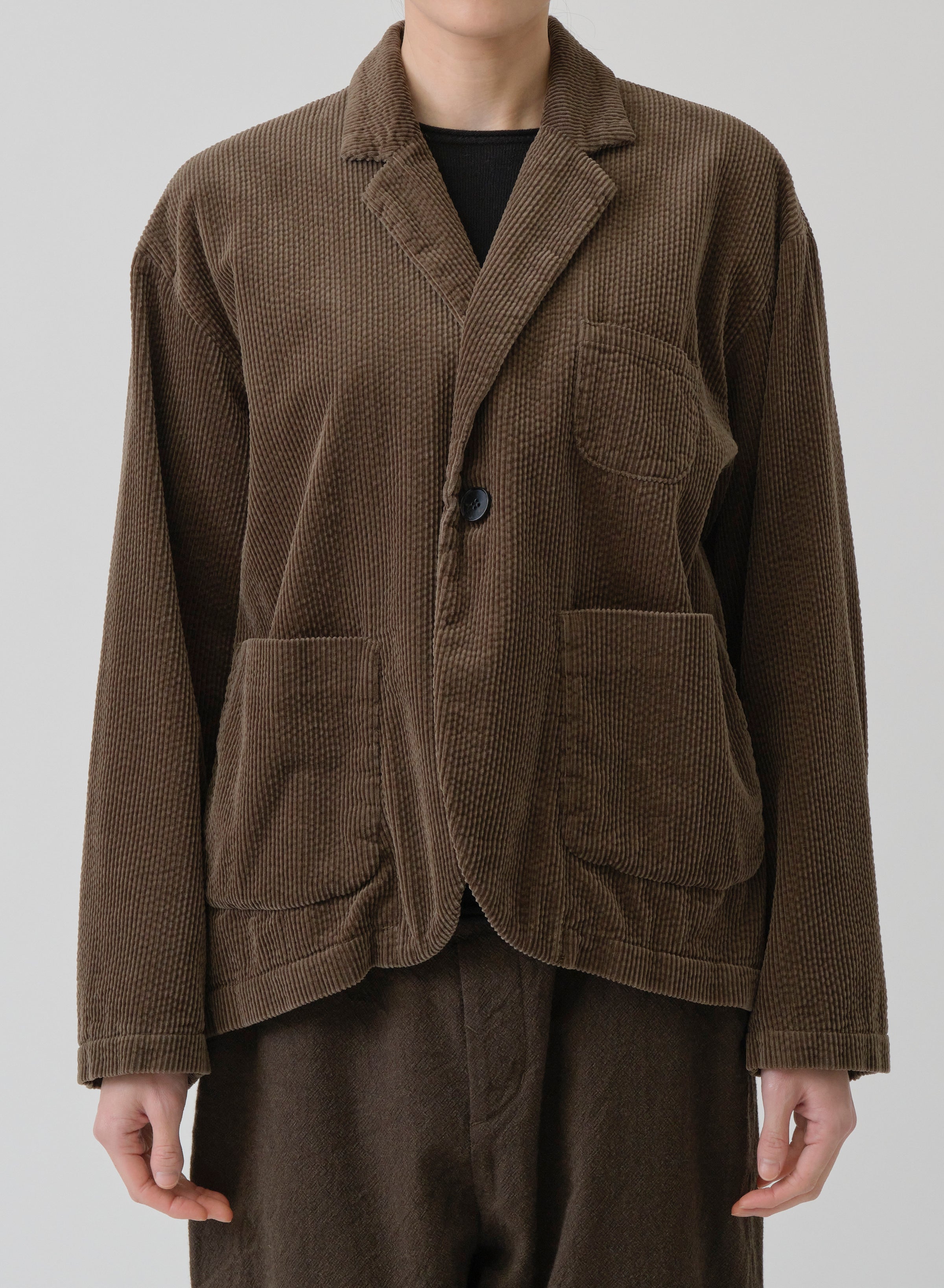 Alt Model on grey backdrop wears PAS DE CALAIS brown cotton corduroy jacket with brown pants