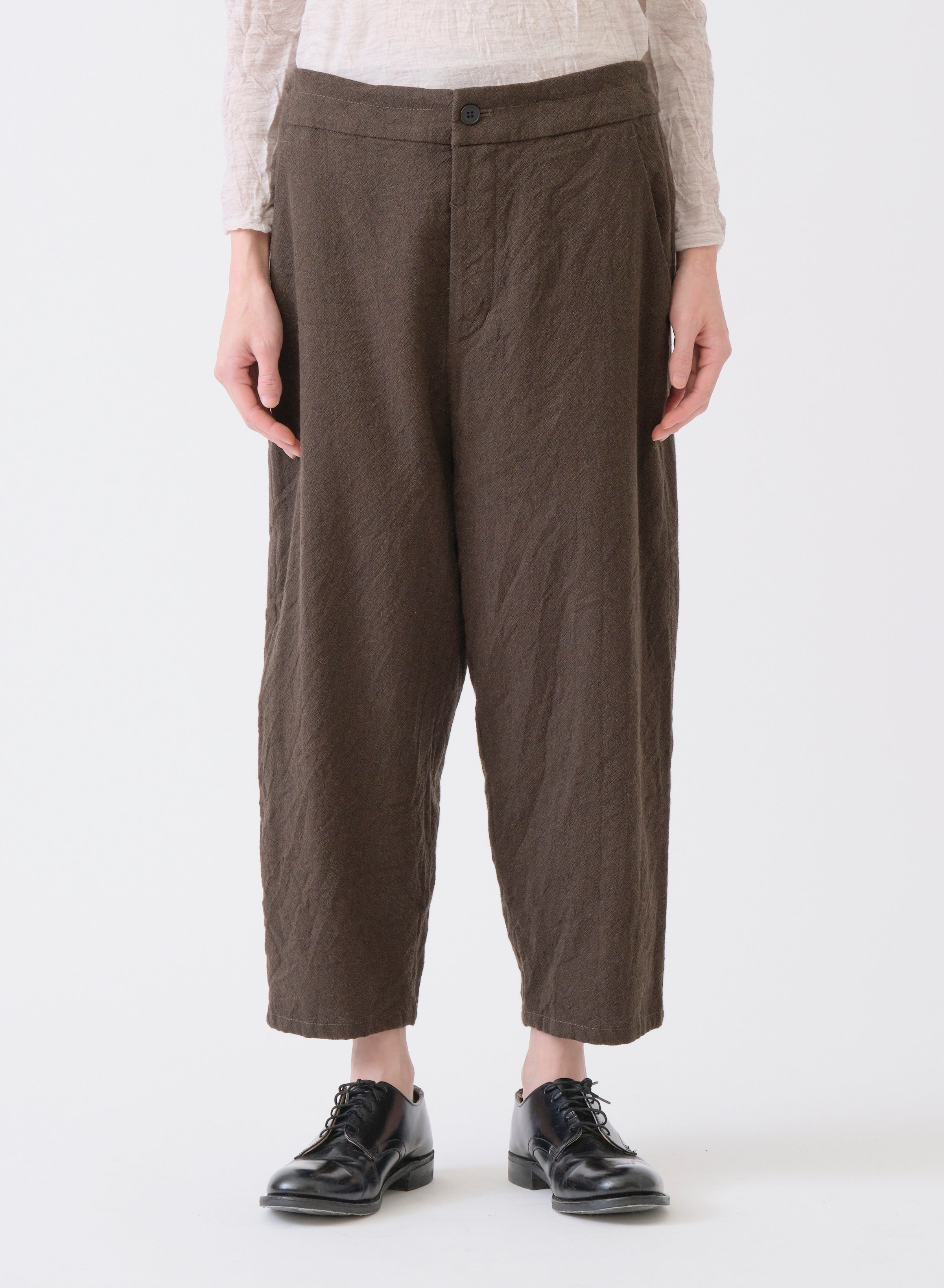 Model on white backdrop wears PAS DE CALAIS Mulesing-Free khaki Cropped pants with black shoes