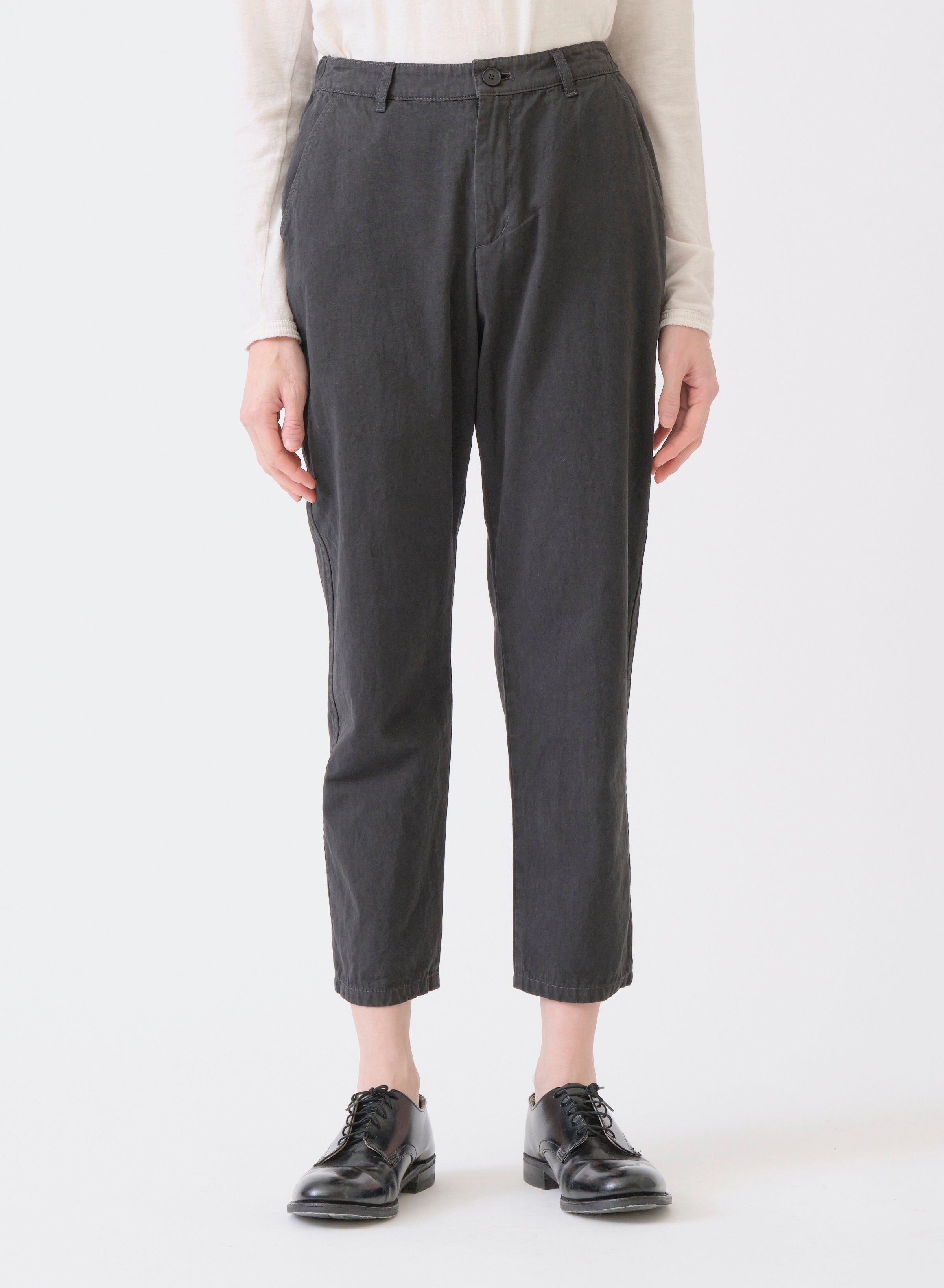 Model from waist down on white backdrop wears PAS DE CALAIS Grosgrain tapered pants in grey with black shoes