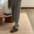 Side view of model on carpet wearing grey knit dress and Sofie D'Hoore Falcone-LVATO shoes.