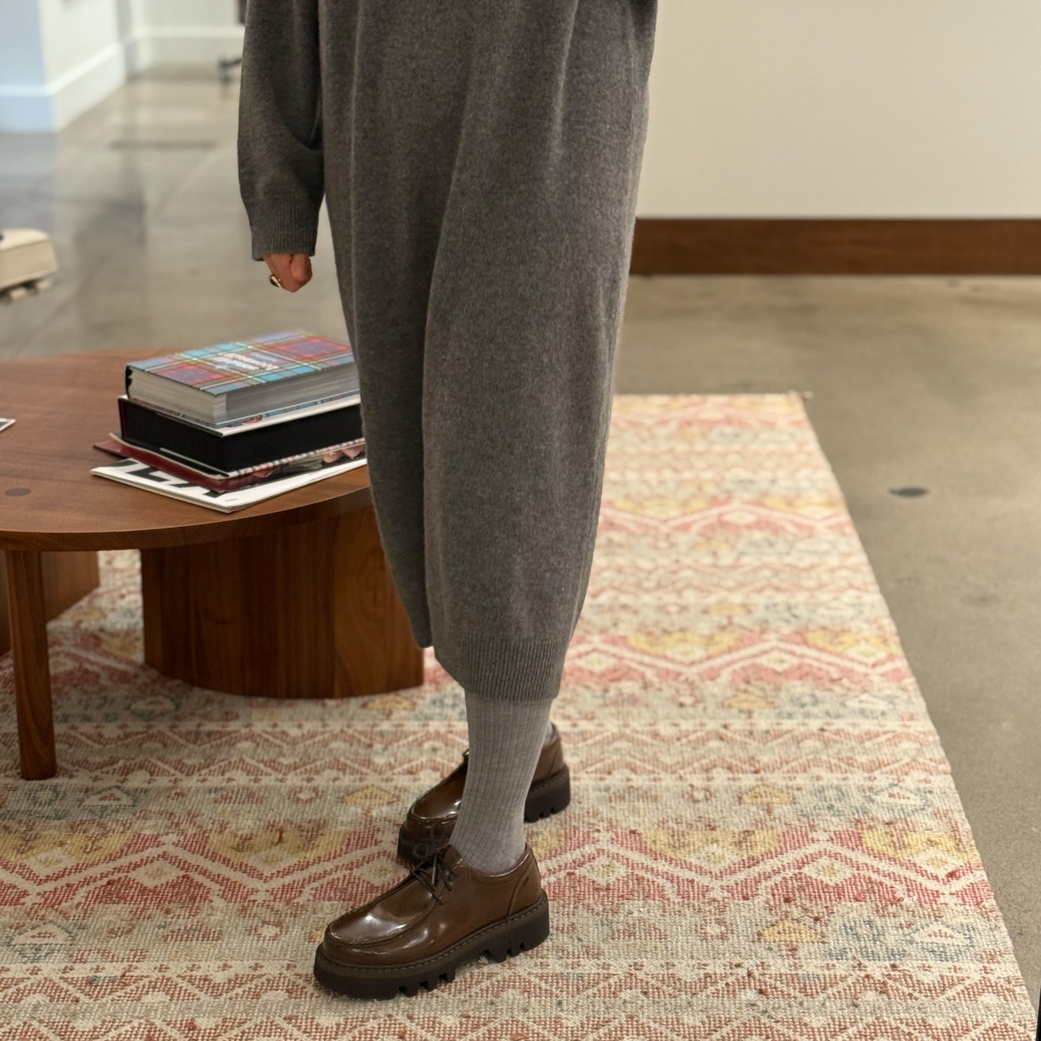 Side view of model on carpet wearing grey knit dress and Sofie D'Hoore Falcone-LVATO shoes.