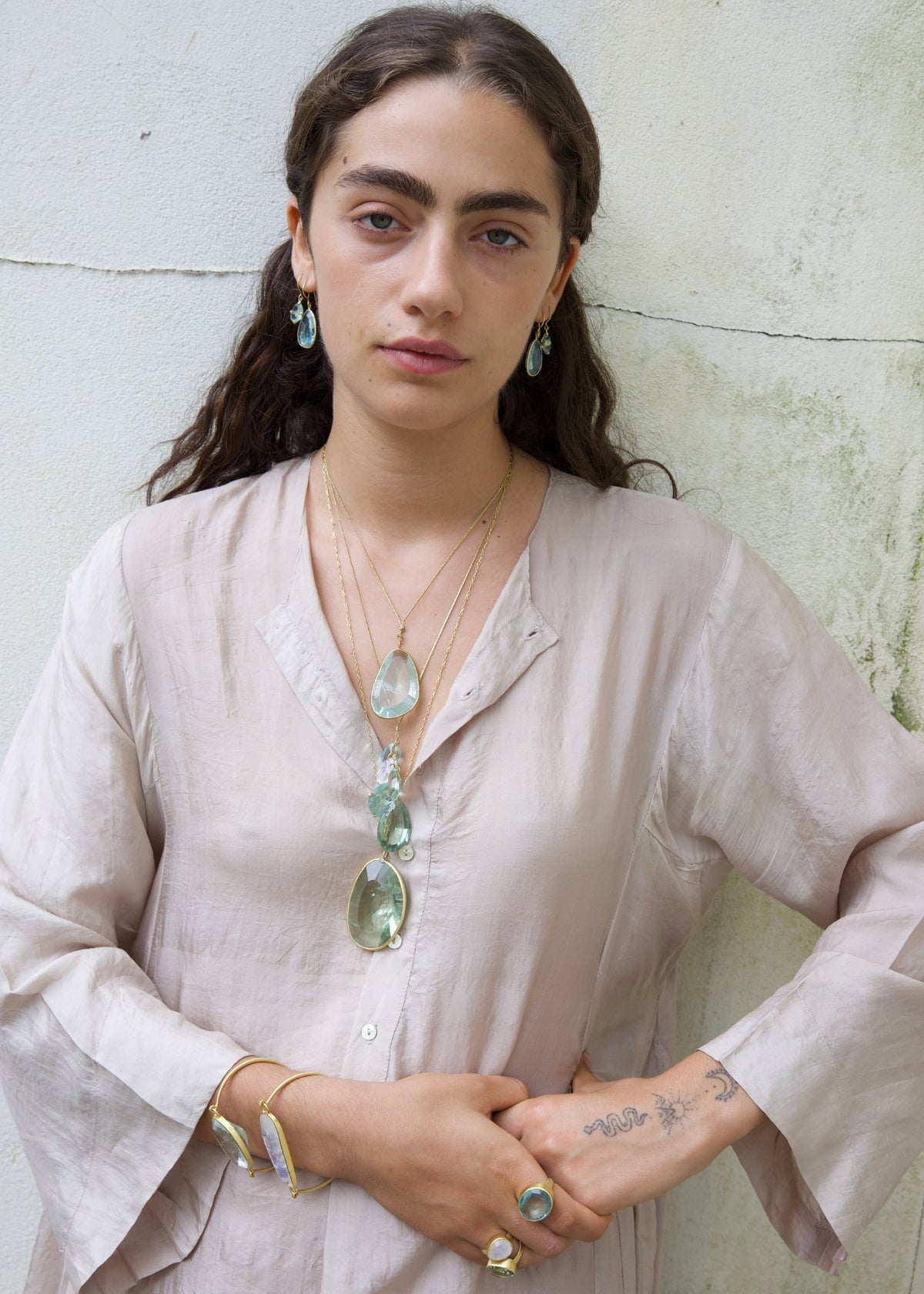 Model wears blush tunic with Pippa Small Colette pendant necklace and stacks of other gemstone jewelry