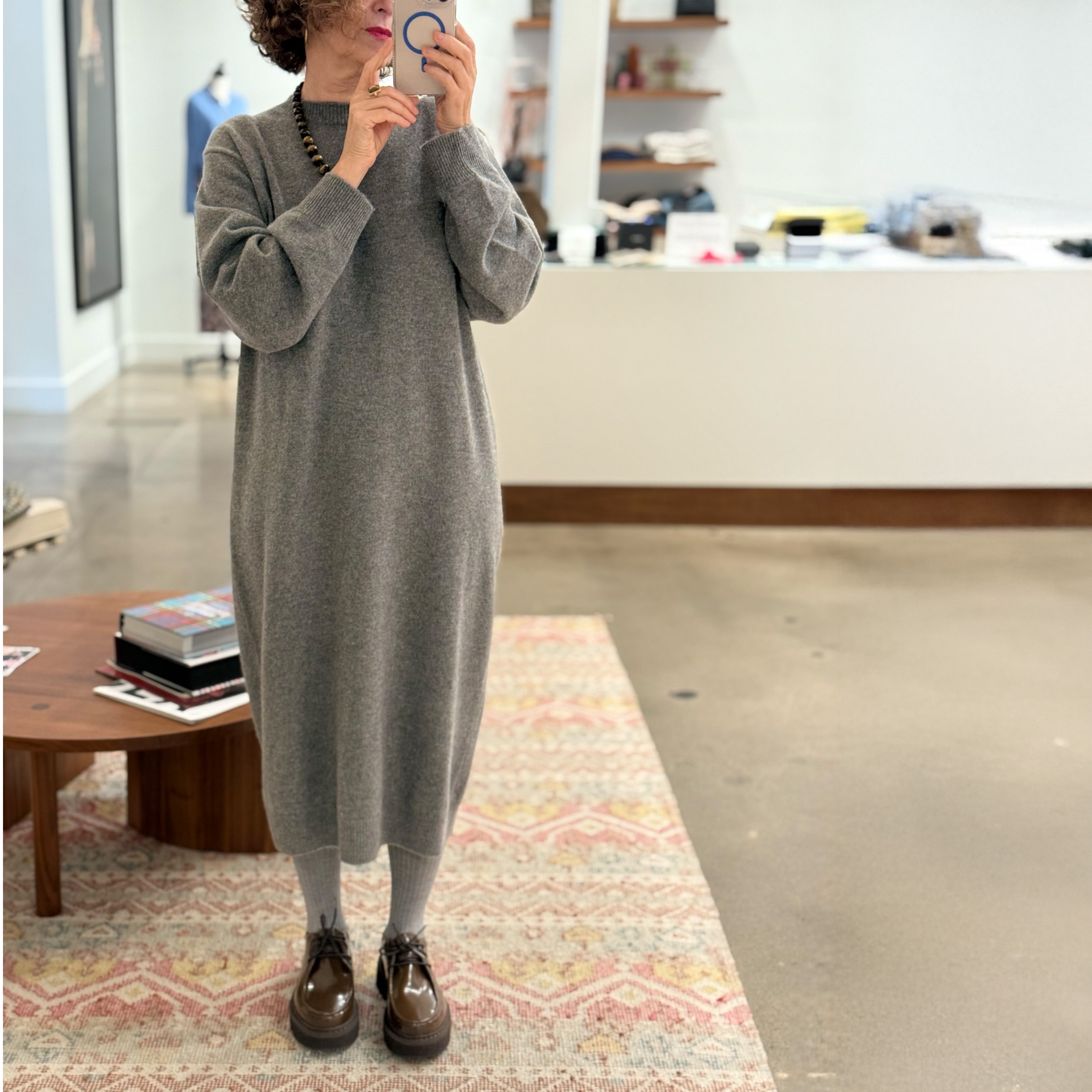Model stands on carpet wearing grey knit dress and Sofie D'Hoore Falcone-LVATO shoes.