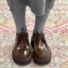 Close-up of model's feet on carpet wearing Sofie D'Hoore Falcone-LVATO shoes with grey ribbed socks