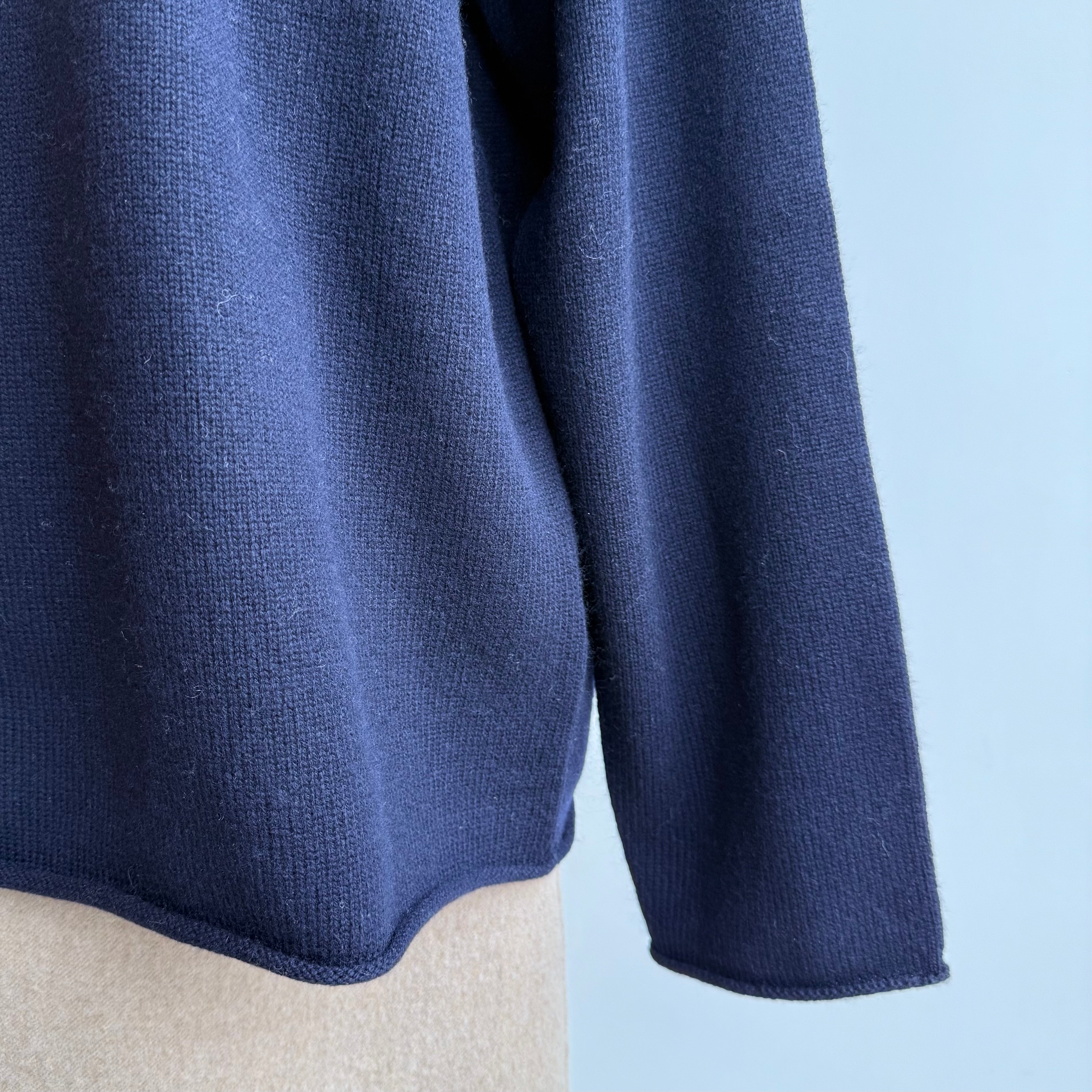 SOFIE D'HOORE MOTEL-YWOC navy v-neck sweater on mannequin, detail of rolled hem