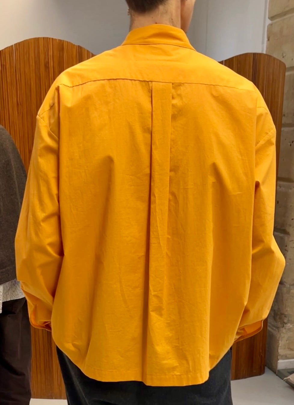 Back side of model wearing Toogood The Physician Shirt button-down in orange