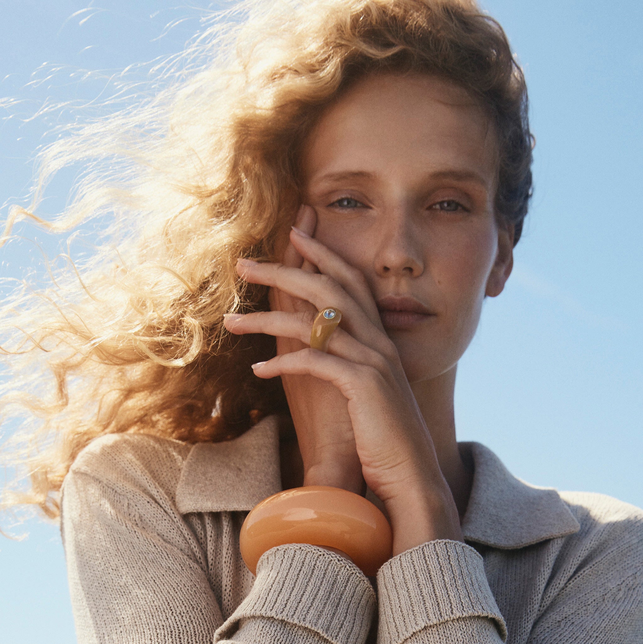 Model wears beige sweater with Arc Cuff in Apricot