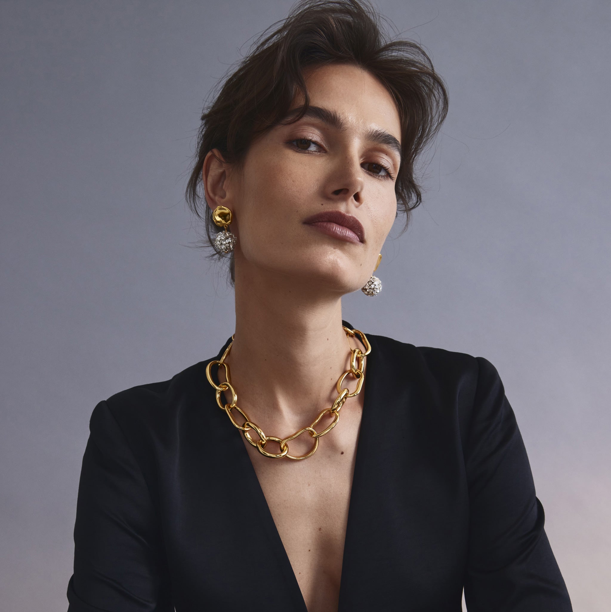 Model in black blazer wears Porto Chain in gold