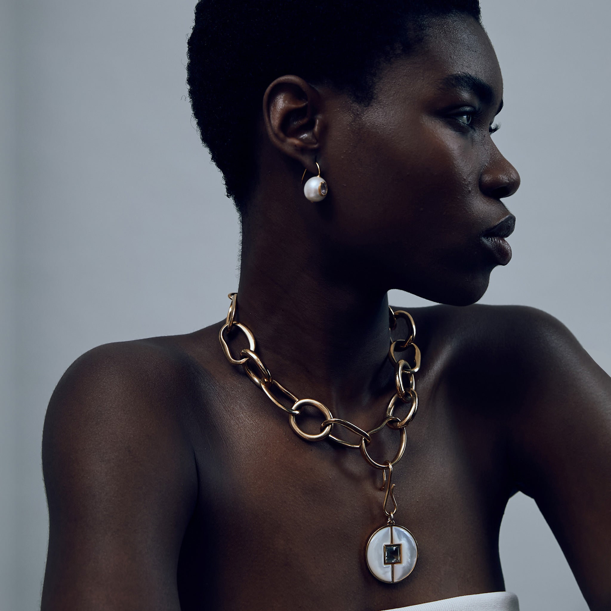 Model wears Porto Chain in Gold with pearl circle pendant