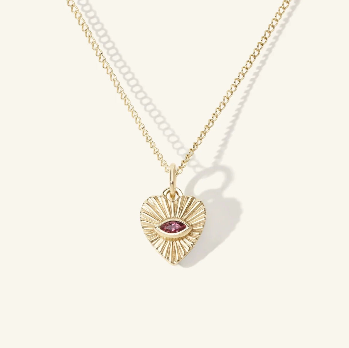 Zahava Mini Tourmaline Heart Charm, a gold heart with sunbeam texture and 'eye' shaped pink tourmaline, on gold chain