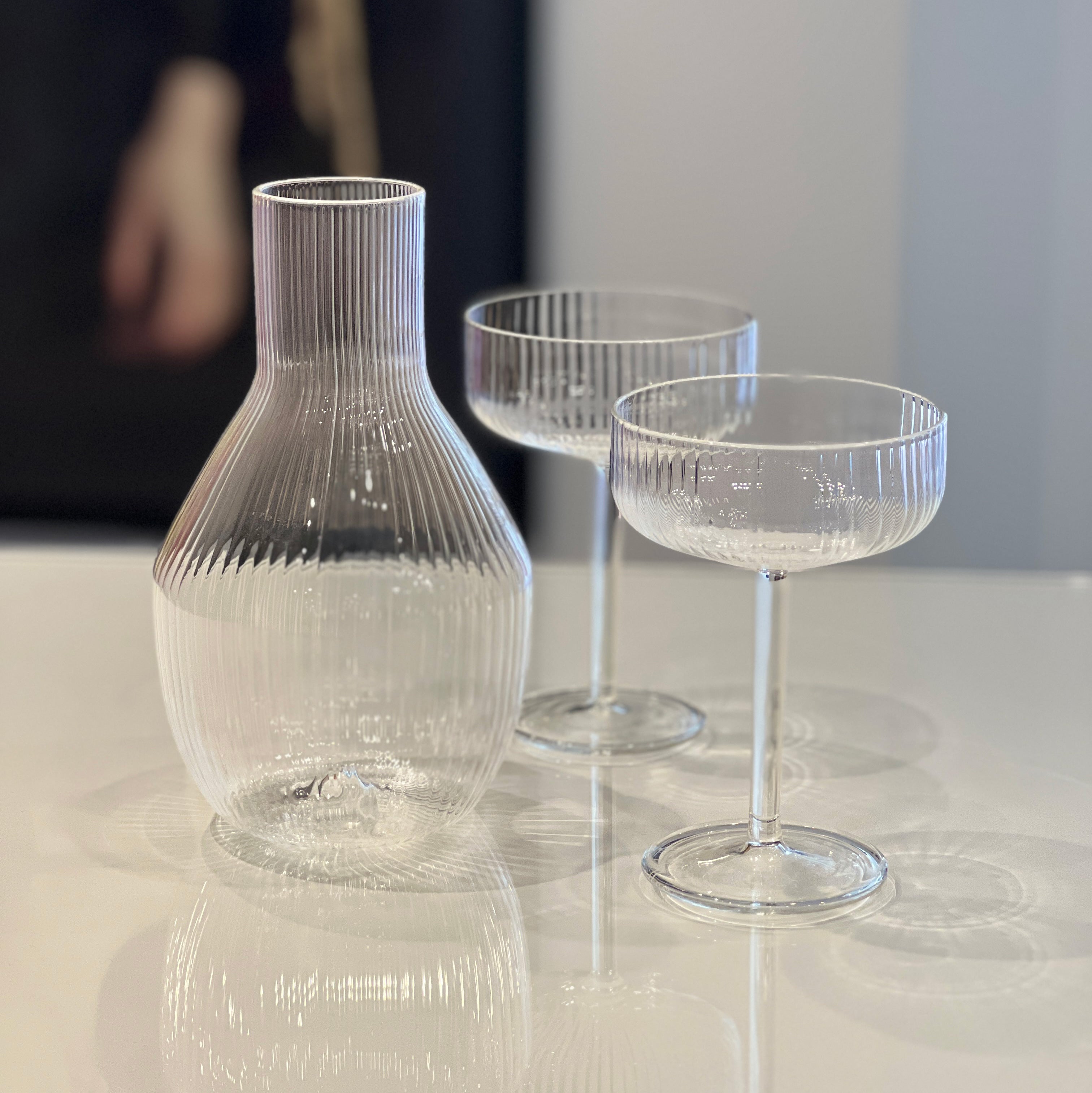 R+D.LAB Tuccio carafe, clear ribbed glass jug with two matching couple glasses on tabletop