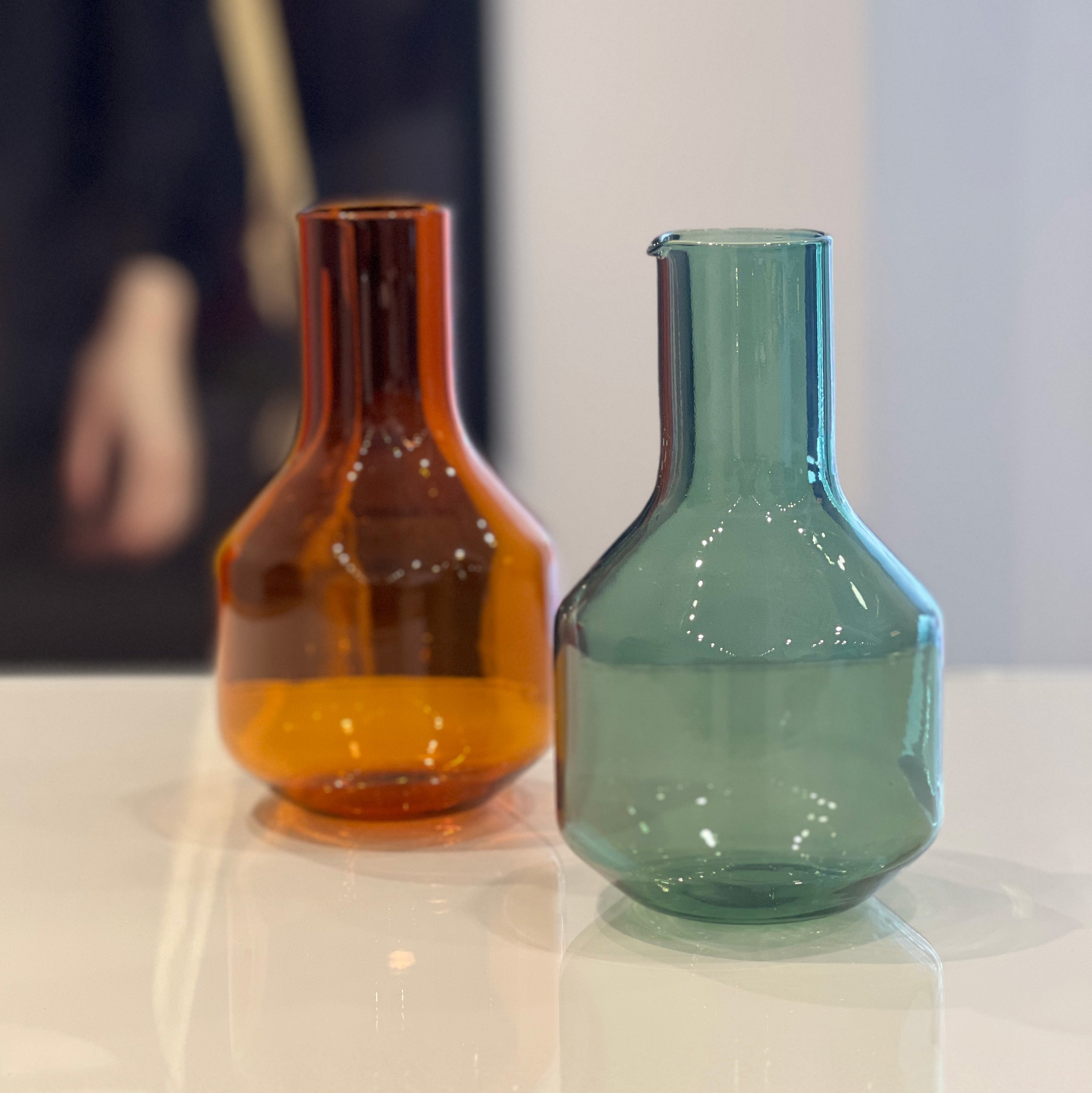 R+D.LAB Velsaca 1L Carafe, orange and aqua glass jugs on tabletop