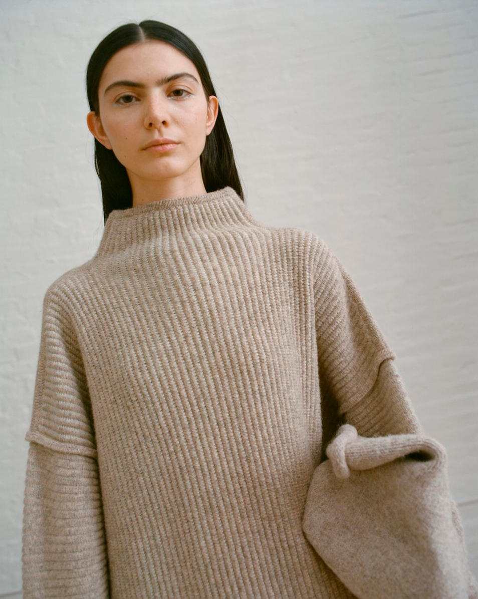 Women in an oversized, brown turtleneck.