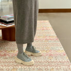 View of model's legs standing on carpet wearing Sofie D'Hoore Fairway Leather Ankle Boots in blue with white chunky soles